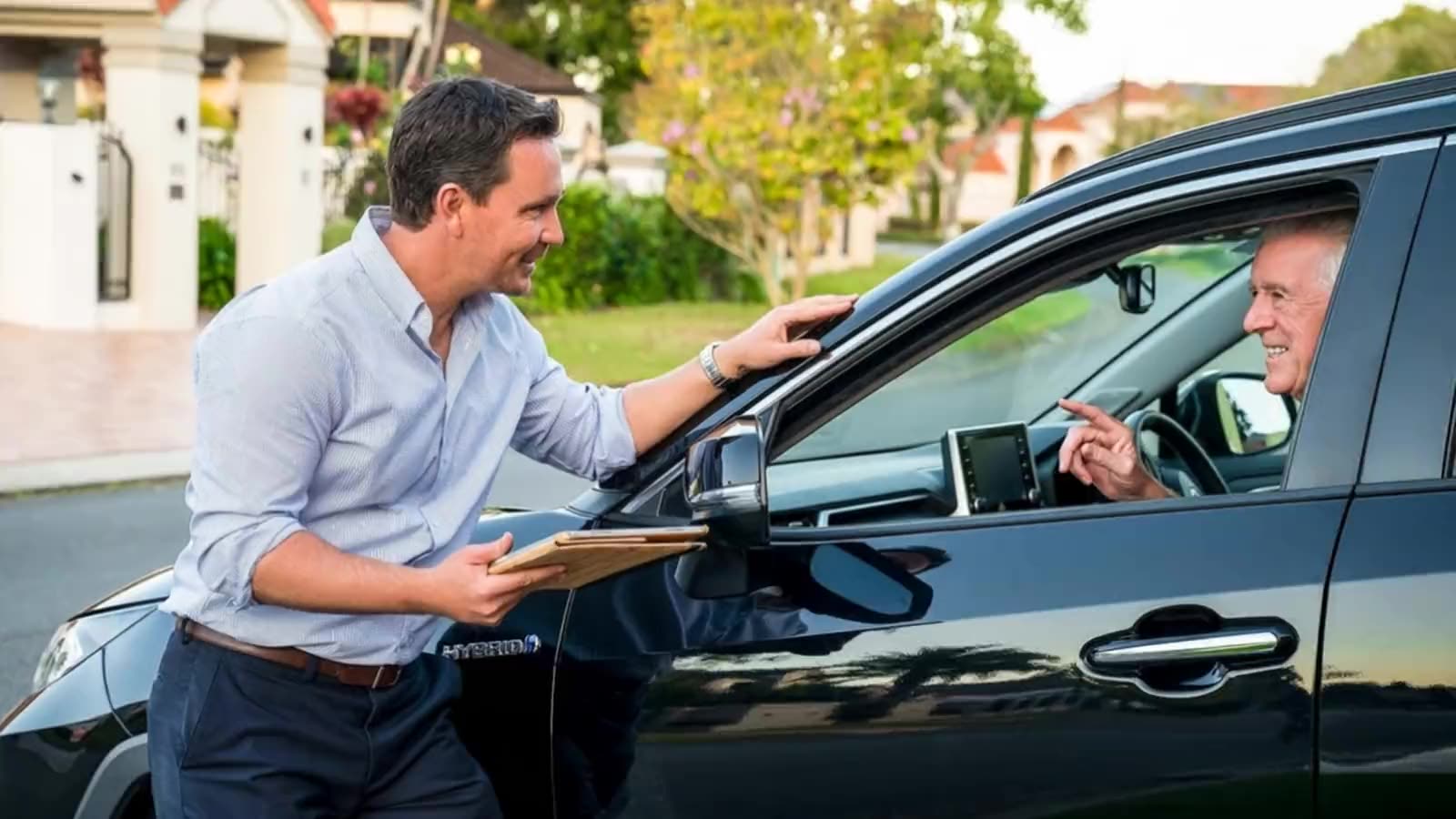 Adam Hall valuing a customer's car in their driveway