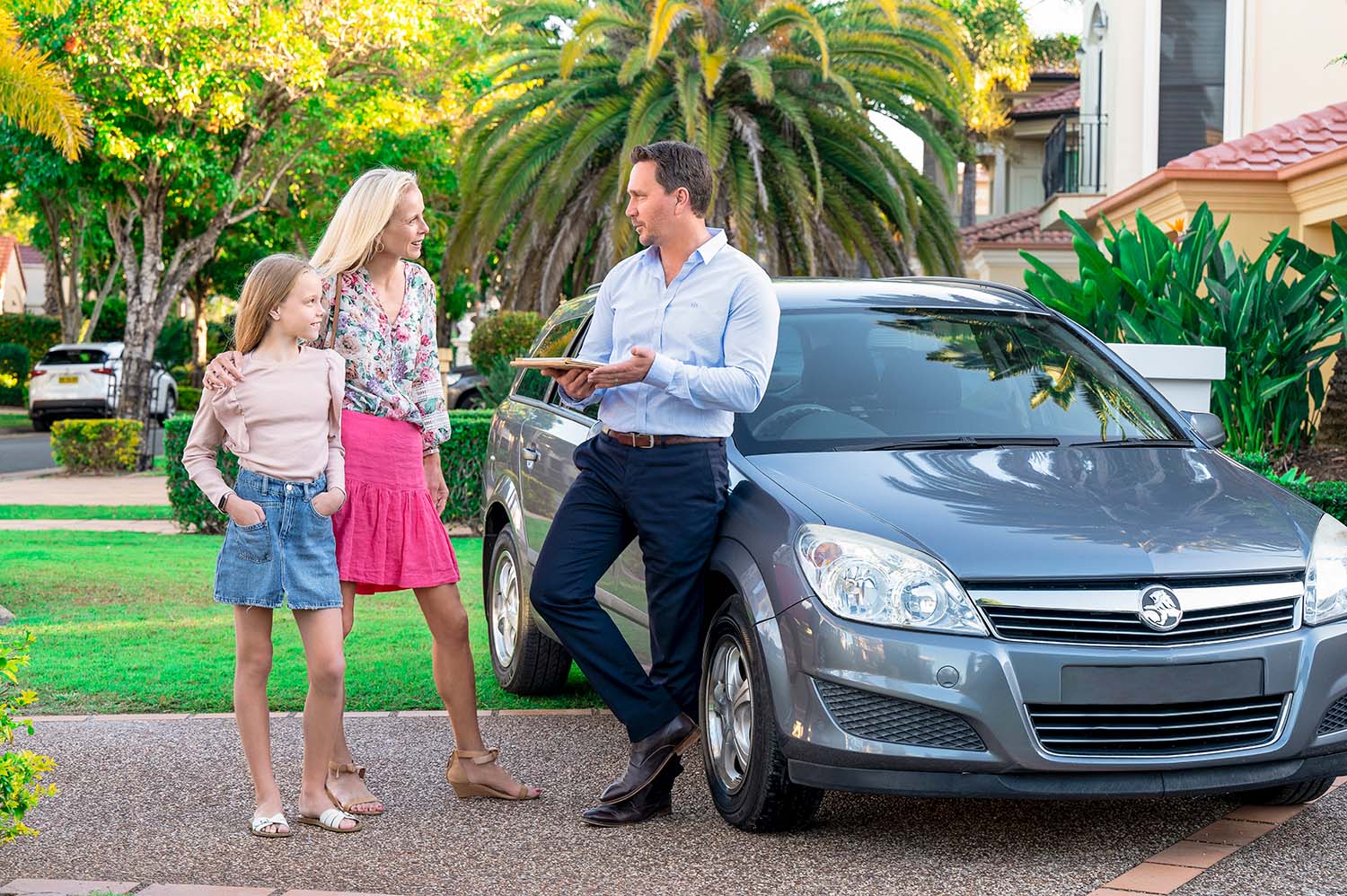 Adam Hall looking over a car in a driveway